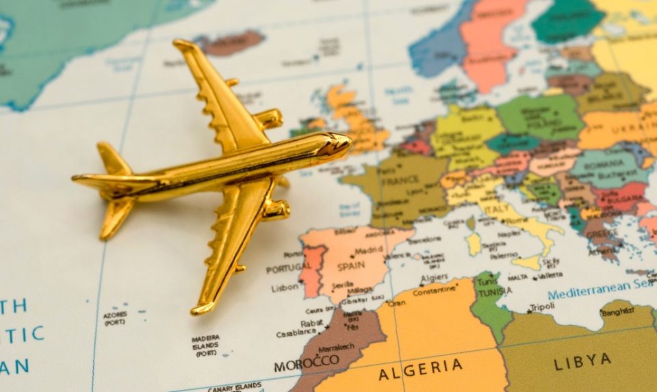 modellino di aereo dorato che vola su una cartina geografica dell'Europa