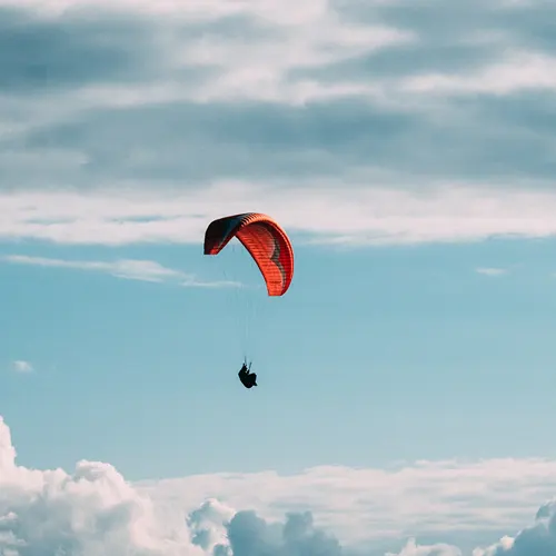 una persona con paracadute aperto in volo nel cielo