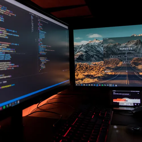 due monitor con una schermata su codici informatici