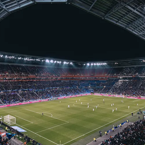 uno stadio pieno di tifosi in cui è iniziata una partita di calcio